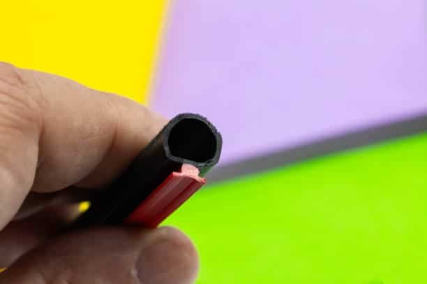 Close-up of black rubber co-extruded profile with red insert, ideal for automotive and industrial applications- Crowns Machinery